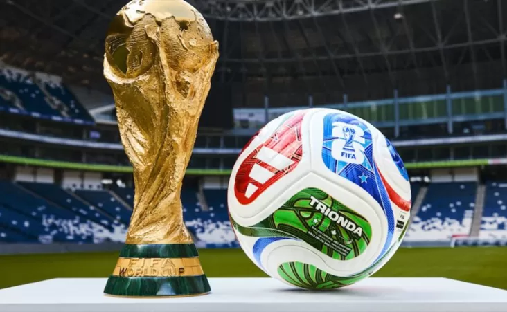 Detalles en dorado evocan la grandeza de la Copa del Mundo, mientras su base blanca de cuatro paneles aerodinámicos y textura ondulada garantizan precisión y control en cada toque.